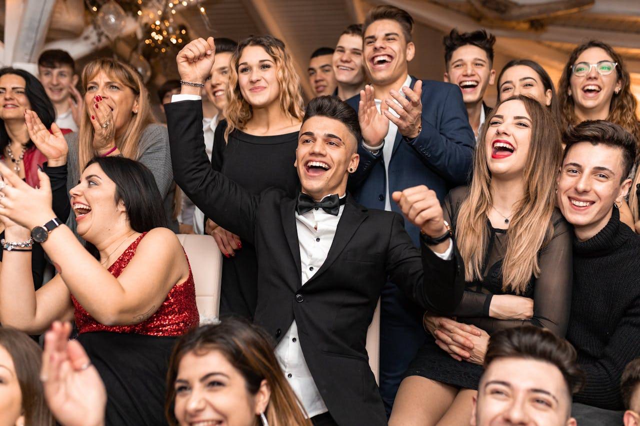 A group of five people in formal wear smiling happily at an event.